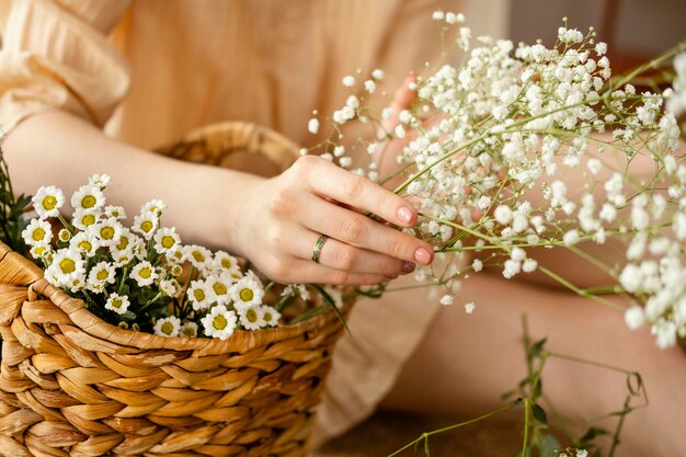 春の花のバスケットを持つ女性