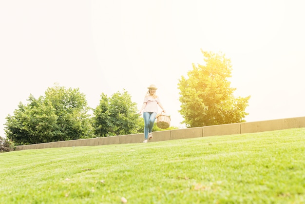 Free photo woman with basket waking in park