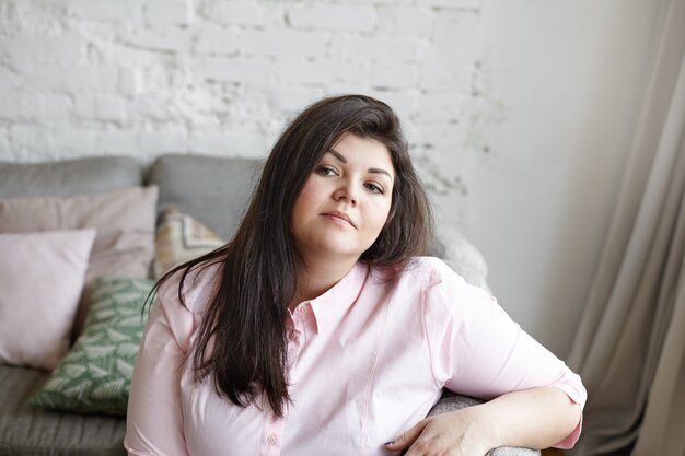 A woman with beautiful body is posing on the couch