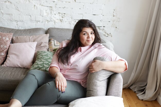 A woman with beautiful body is posing on the couch