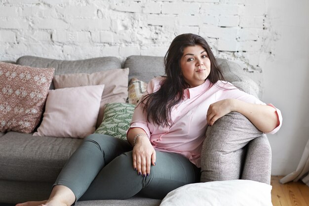 Женщина с красивым телом позирует на диване