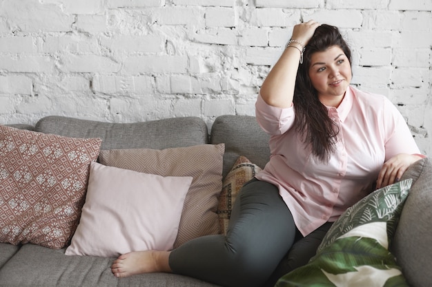 A woman with beautiful body is posing on the couch