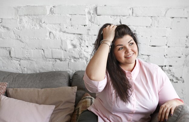 A woman with beautiful body is posing on the couch