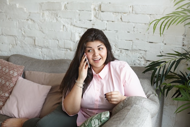 A woman with beautiful body is posing on the couch