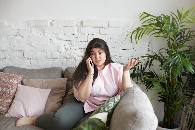 A woman with beautiful body is posing on the couch