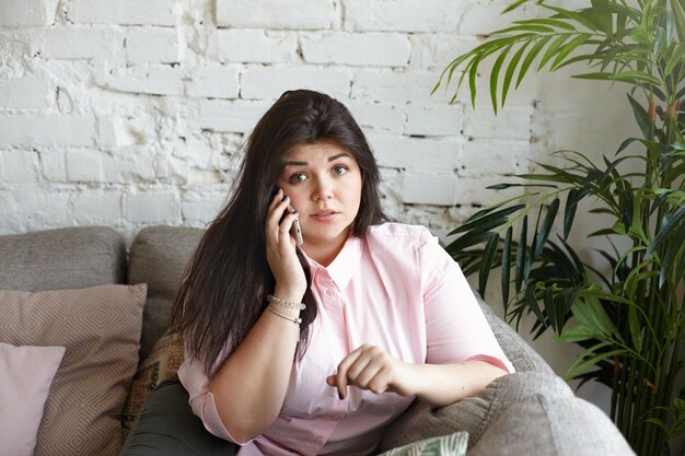 A woman with beautiful body is posing on the couch