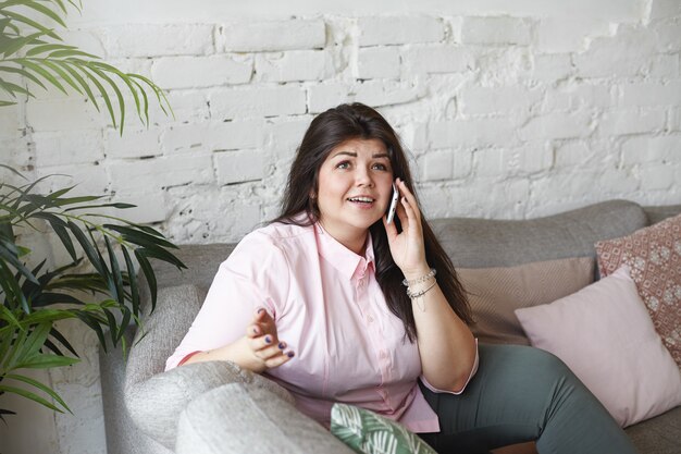 A woman with beautiful body is posing on the couch