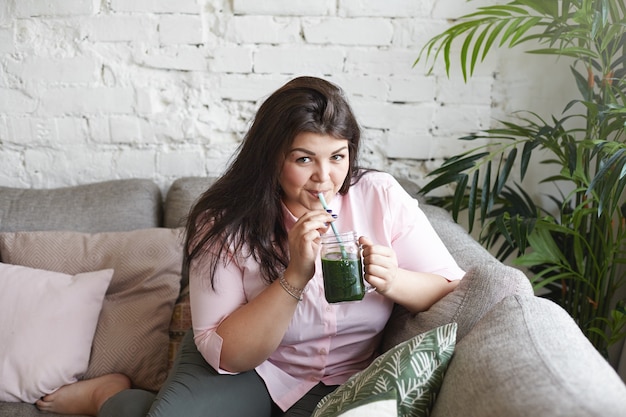 A woman with beautiful body is posing on the couch