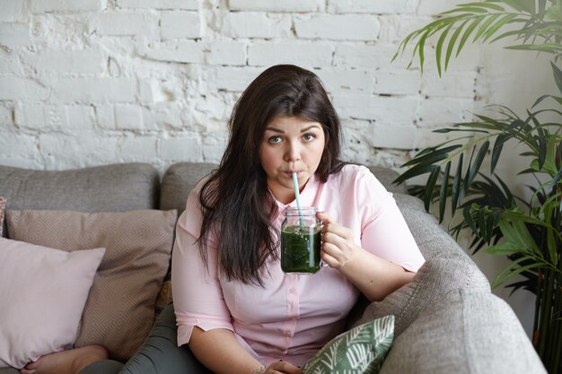 A woman with beautiful body is posing on the couch