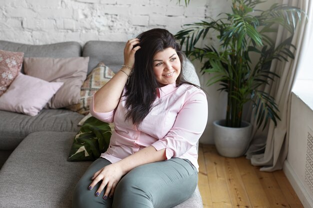 A woman with beautiful body is posing on the couch