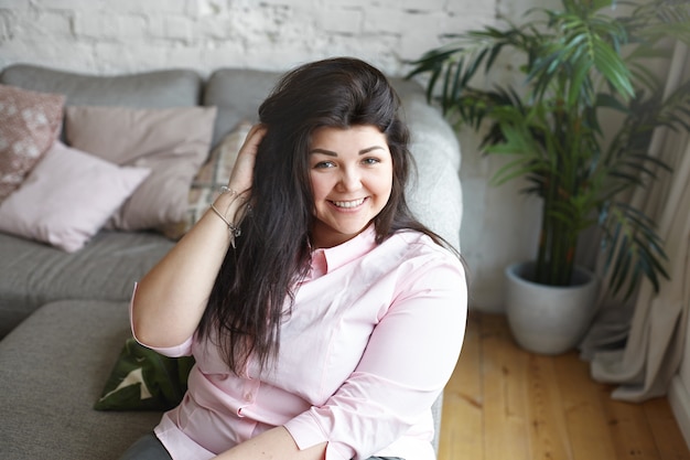 A woman with beautiful body is posing on the couch