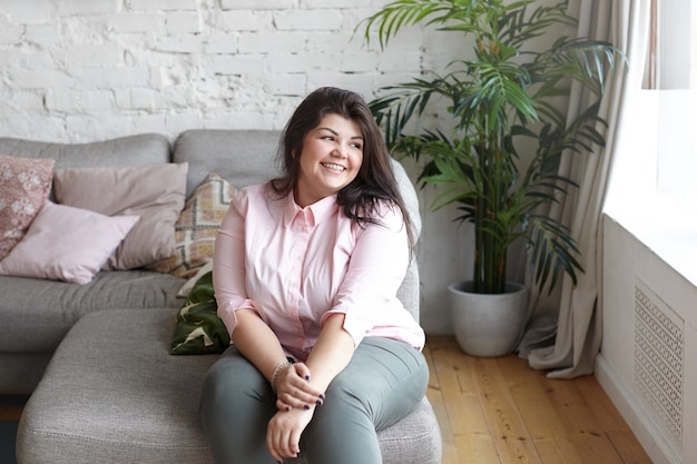 A woman with beautiful body is posing on the couch