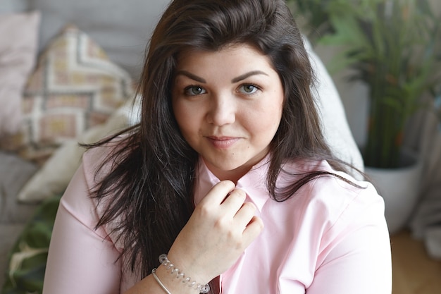 A woman with beautiful body is posing on the couch