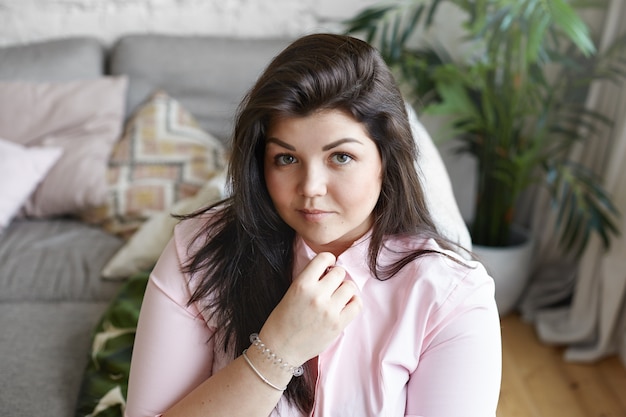 A woman with beautiful body is posing on the couch