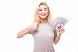 Free photo woman with beautiful face and body holding hand fan made of banknotes on white wall