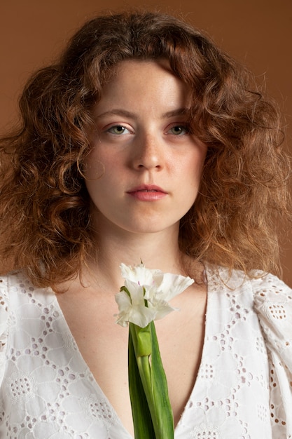 Бесплатное фото Женщина с красивыми цветами гладиолуса