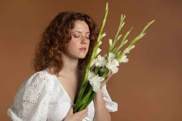 美しいグラジオラスの花を持つ女性