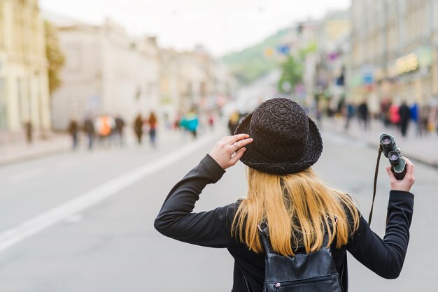 Woman with binoculars on street