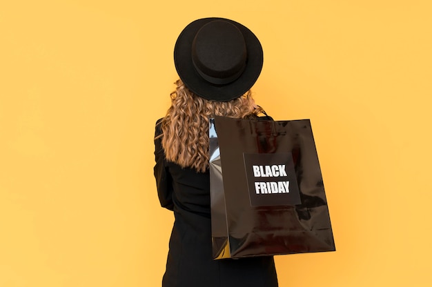 Free photo woman with black friday bag from behind shot