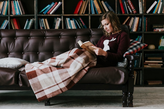 Woman with blanket reading book
