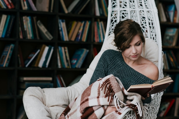 Woman with blanket reading book