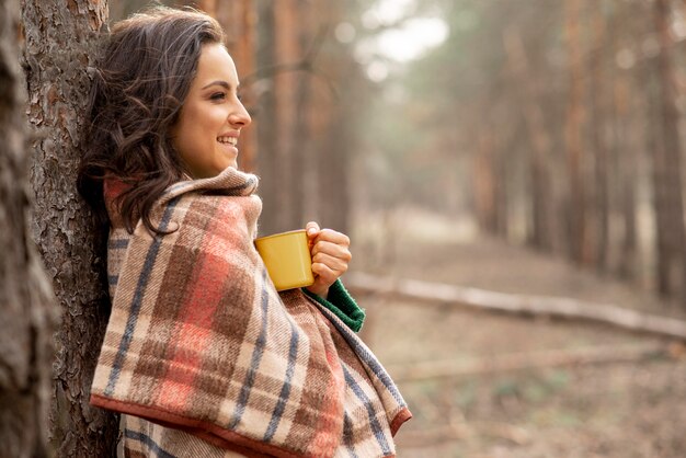 毛布と紅茶のカップを持つ女性