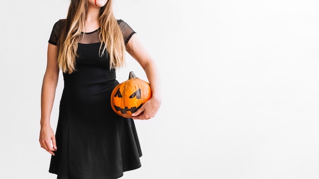 Free photo woman with blood on chin in black dress holding pumpkin