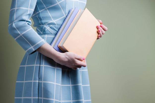 Woman with blue dress and two books