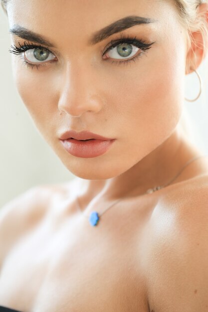 Woman with blue eyes wearing eyeliner and pink lipstick