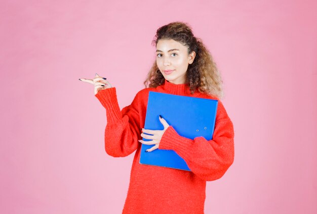 woman with a blue folder pointing to the left.