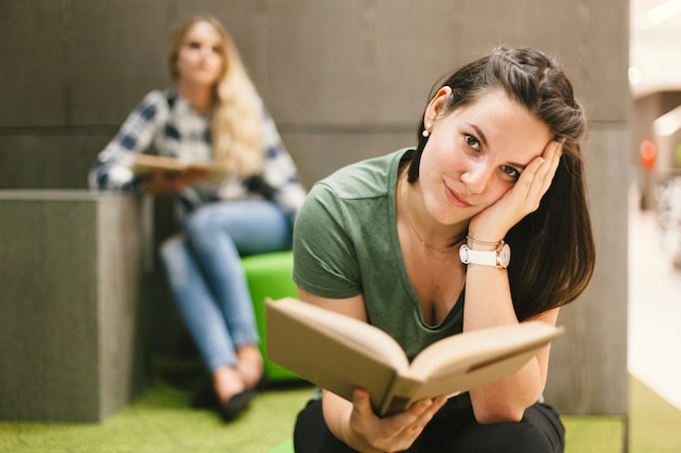 Foto gratuita donna con libro guardando la fotocamera