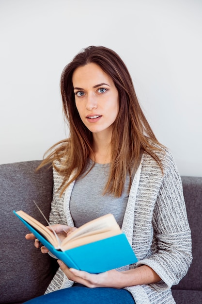 Foto gratuita donna con libro guardando la fotocamera