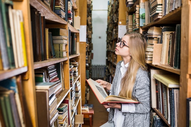 Foto gratuita donna con libro alzando lo sguardo