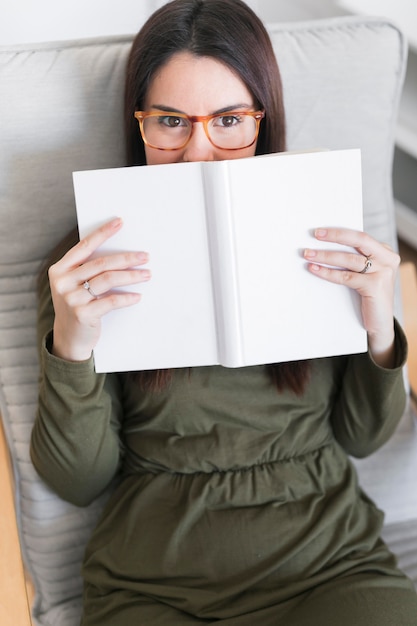 Foto gratuita donna con libro seduto sulla sedia