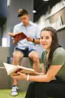 Free photo woman with book smiling at camera