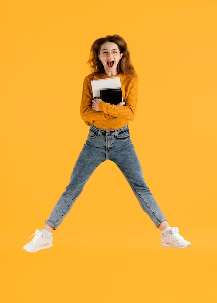 Woman with books jumping