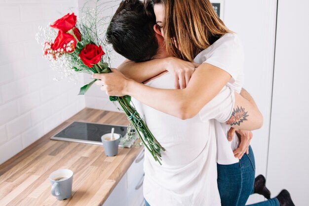 Woman with bouquet hugging man