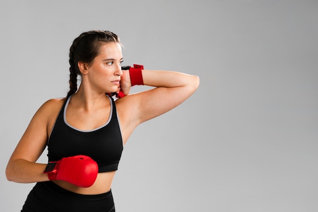 Free photo woman with box gloves looking away and copy space background