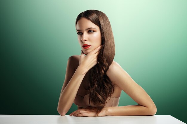 Woman with a bright makeup in a green room with table