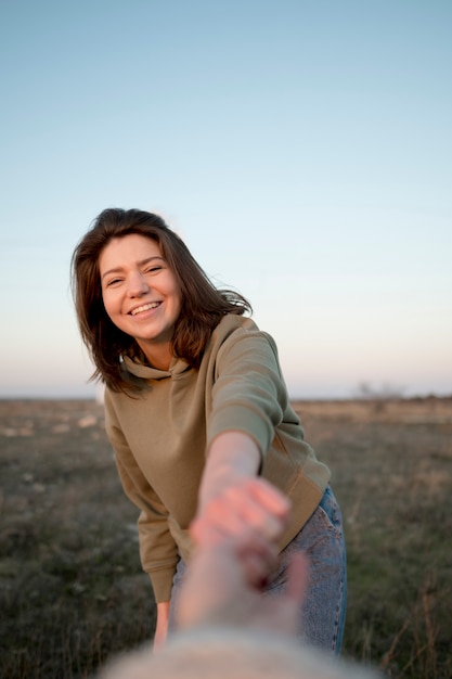 Free photo woman with brown hair holding hands with her friend