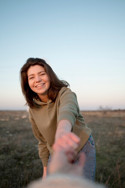 Woman with brown hair holding hands with her friend