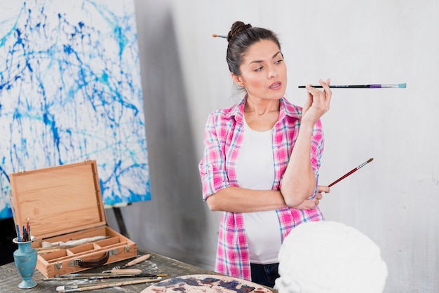 Foto gratuita donna con pennello in studio d'arte