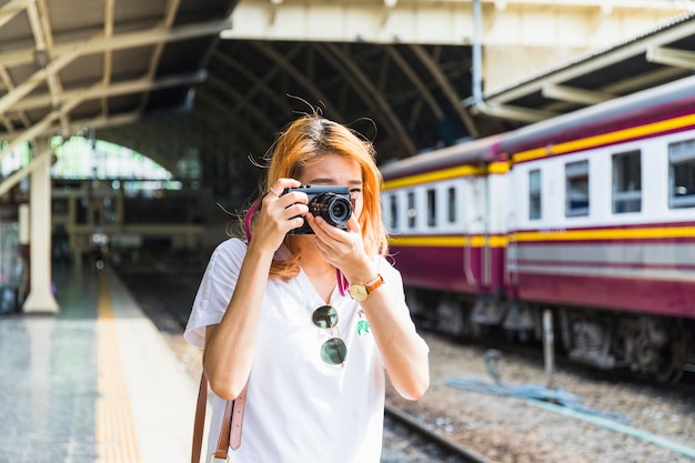 Woman with camera on railway station
