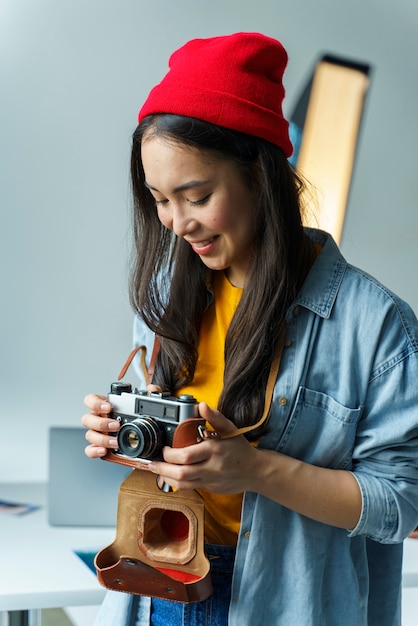 Foto gratuita donna con cappello da portare della macchina fotografica