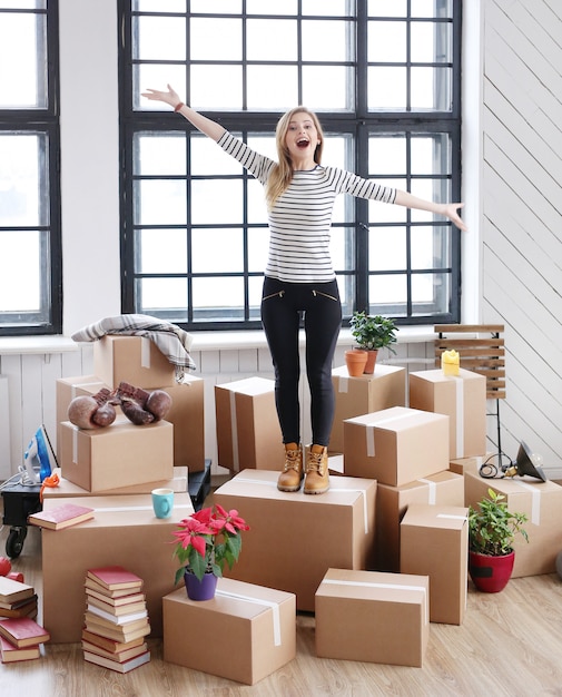 Foto gratuita donna con pacchi cargo pronti per la spedizione o in movimento, in piedi e ridendo