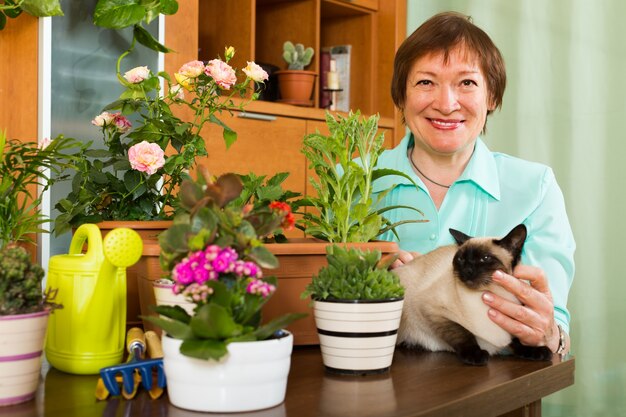 猫と花の植物を持つ女性