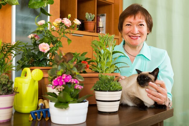 Женщина с растениями кошки и цветка