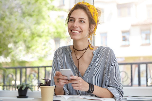 woman with charming smile sitting at terrace with book