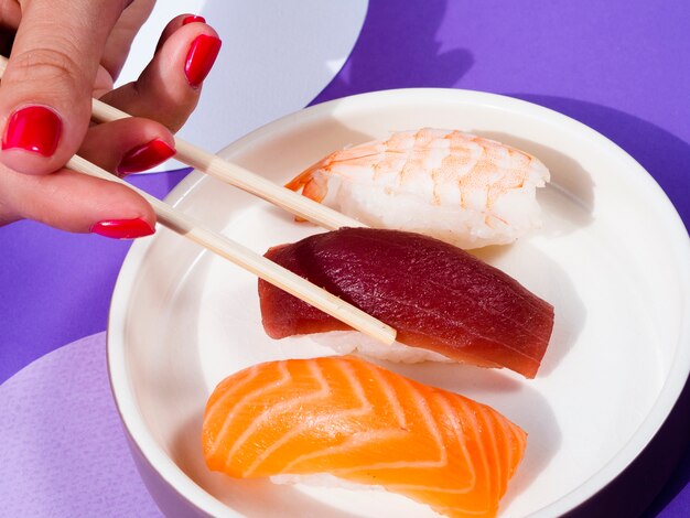 Бесплатное фото Женщина с палочками для еды, принимающая форму суши тунца