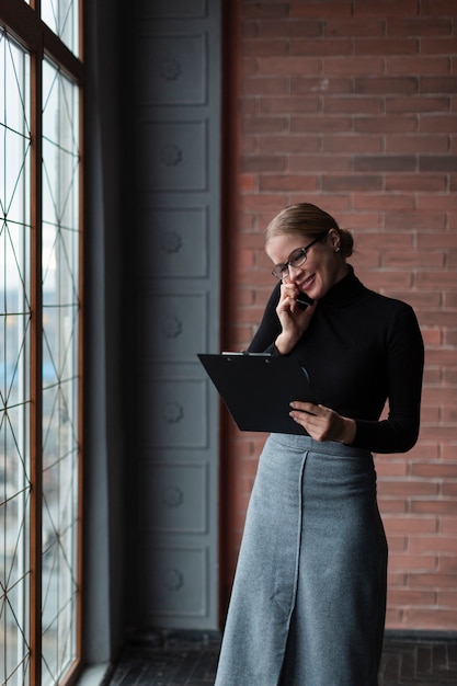 Woman with clipboard talking over phone